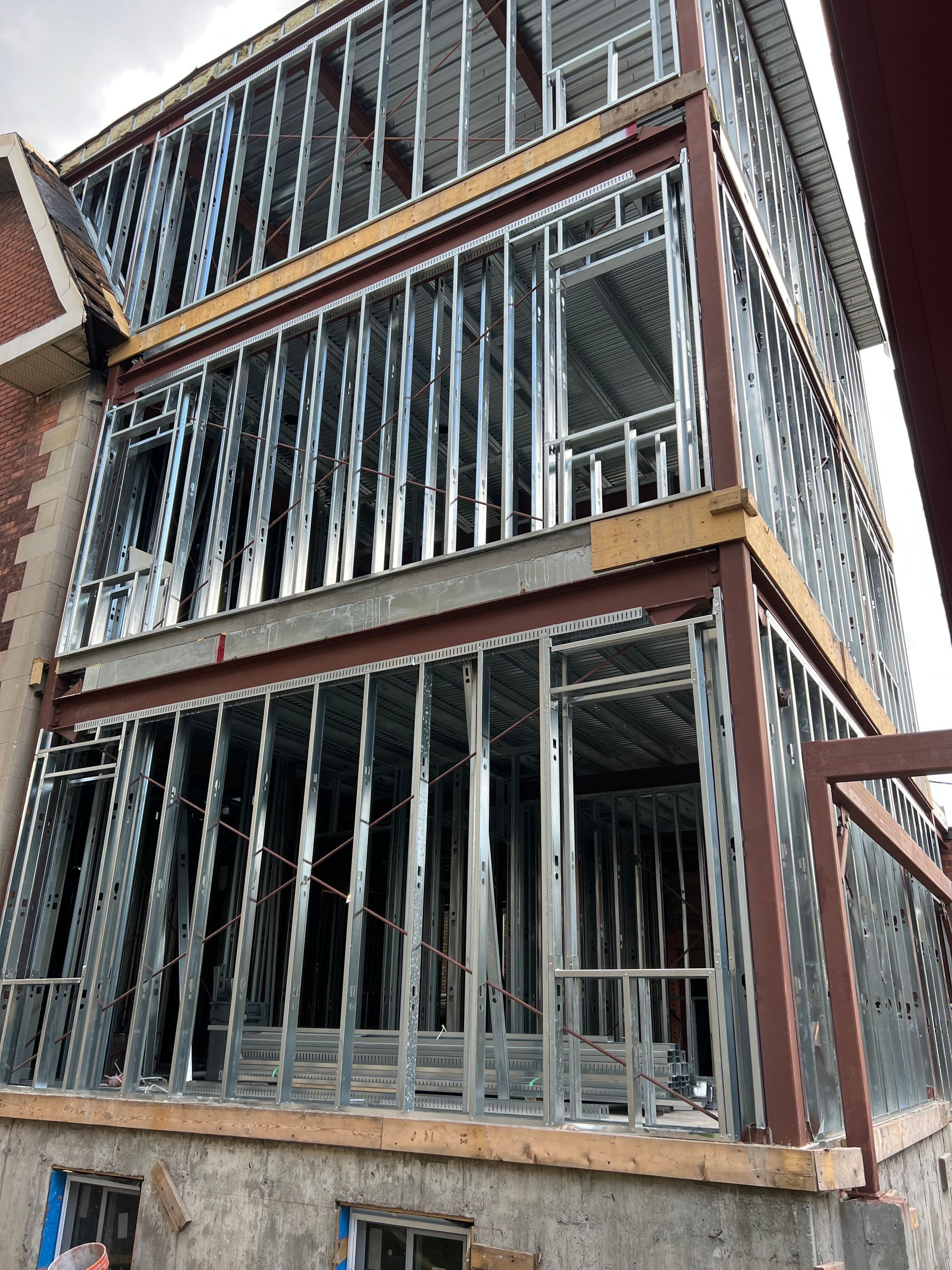 Bâtiment à ossature métallique en construction, avec montants métalliques verticaux et planchers apparents