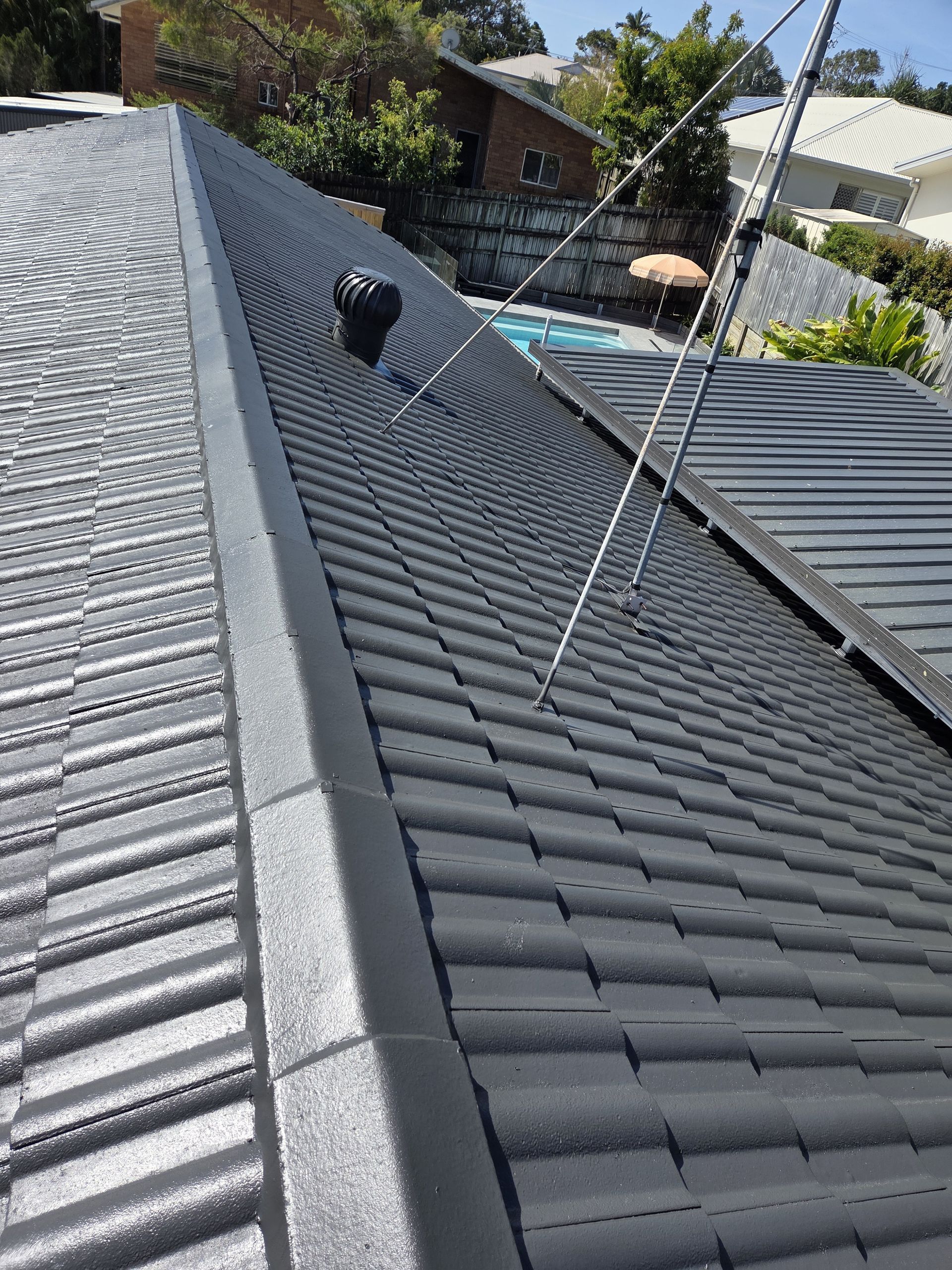 Dark Roof with Pool in Background — MVP Painting Professionals in Sippy Downs, QLD