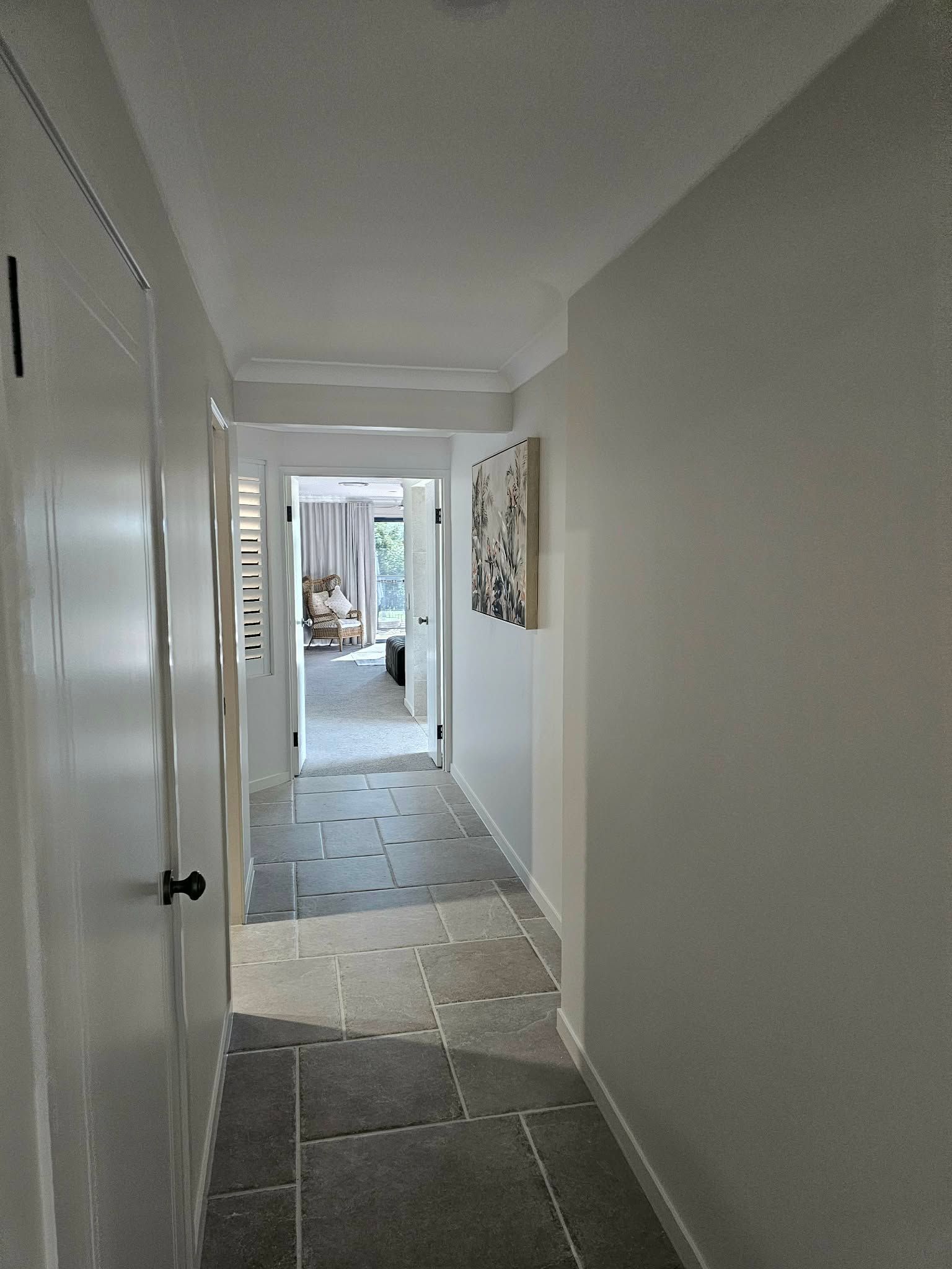 Long, Narrow Hallway With Light Gray Walls, Dark Flooring, and a Door at the End — MVP Painting Professionals in Caloundra, QLD