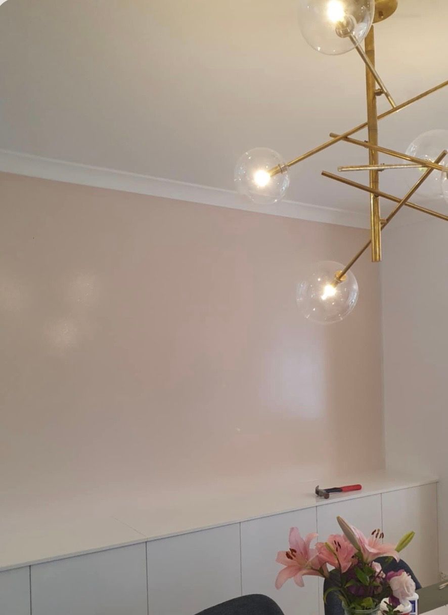 Pink wall with white trim, gold chandelier, built-in white cabinets, and pink flowers— MVP Painting Professionals in Sunshine Coast, QLD