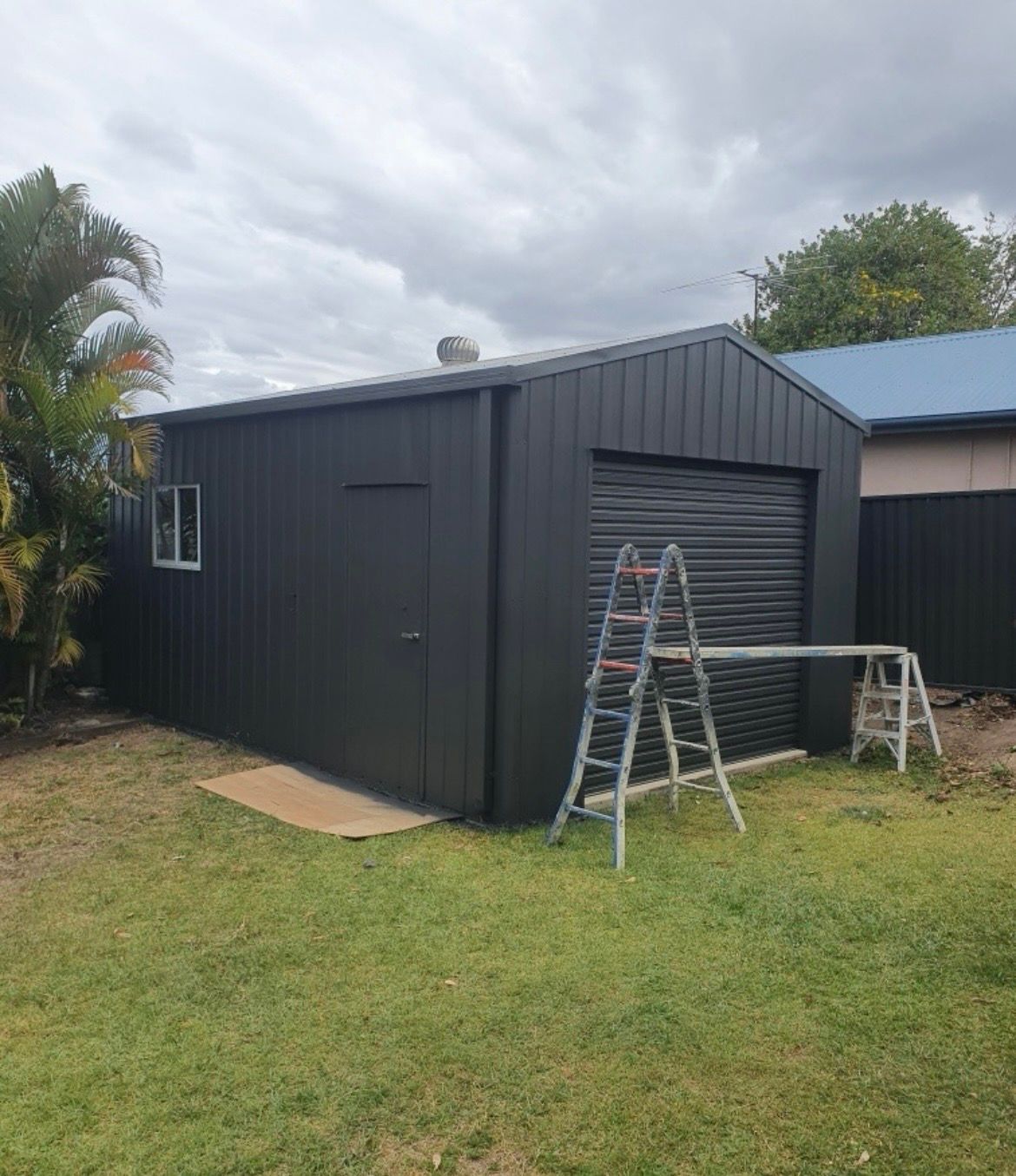 Dark Gray Shed With a Roller Door, Window, and Door — MVP Painting Professionals in Glass House Mountains, QLD