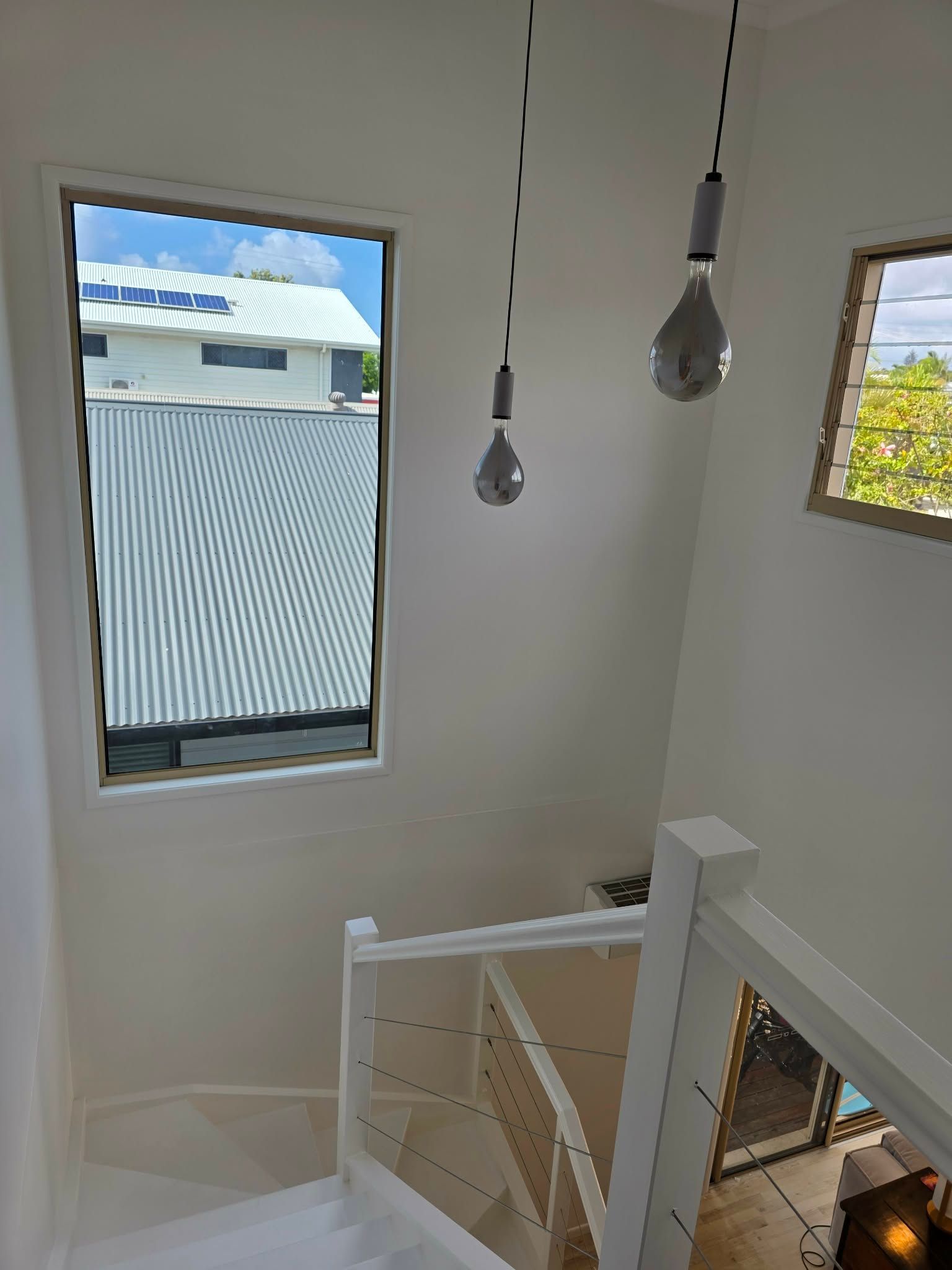 Staircase Hallway with Two Drop Down Lightbulbs, and Large Window — MVP Painting Professionals in Caloundra, QLD