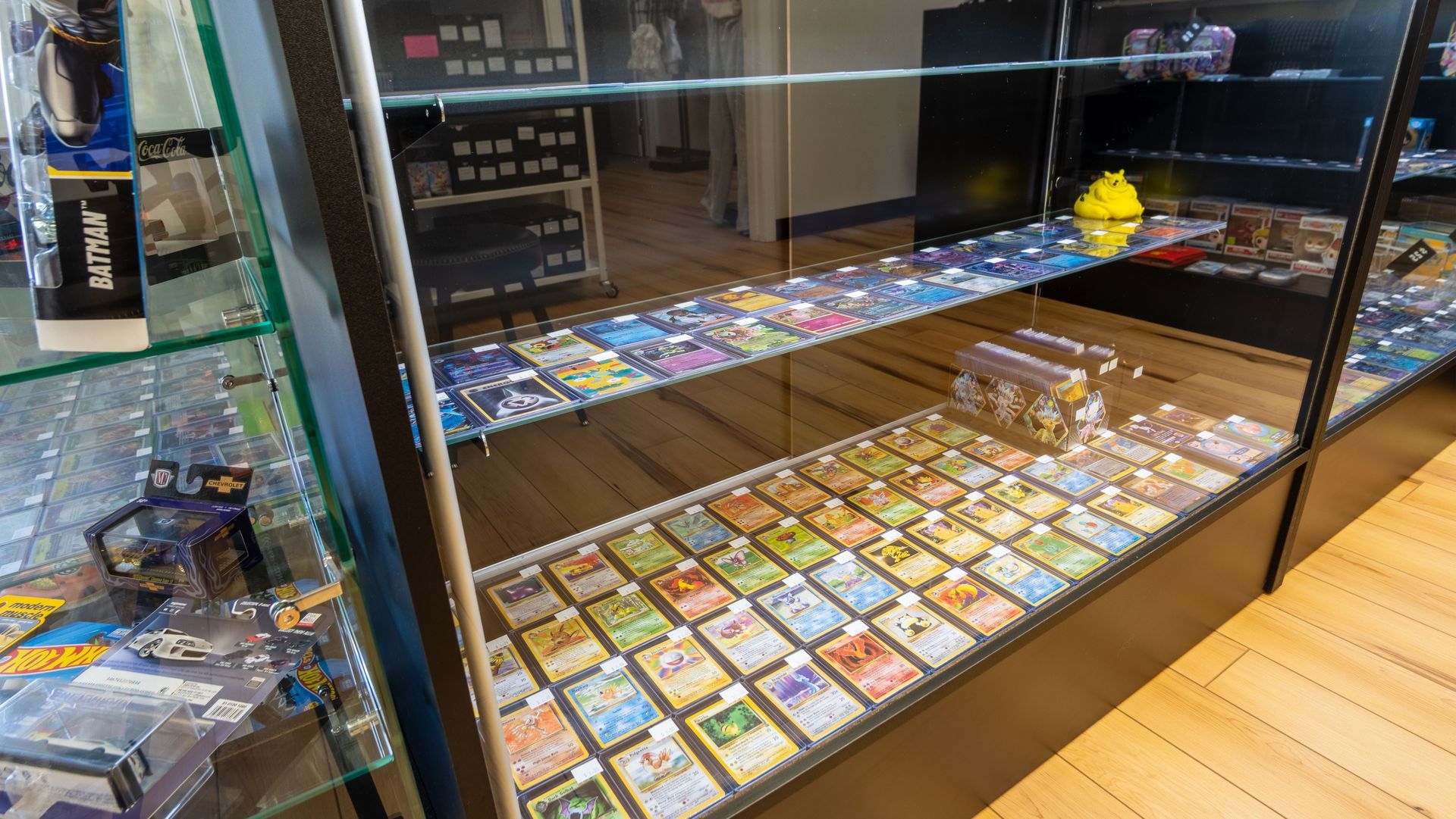 Display case filled with colorful trading cards and comic books behind glass in a shop