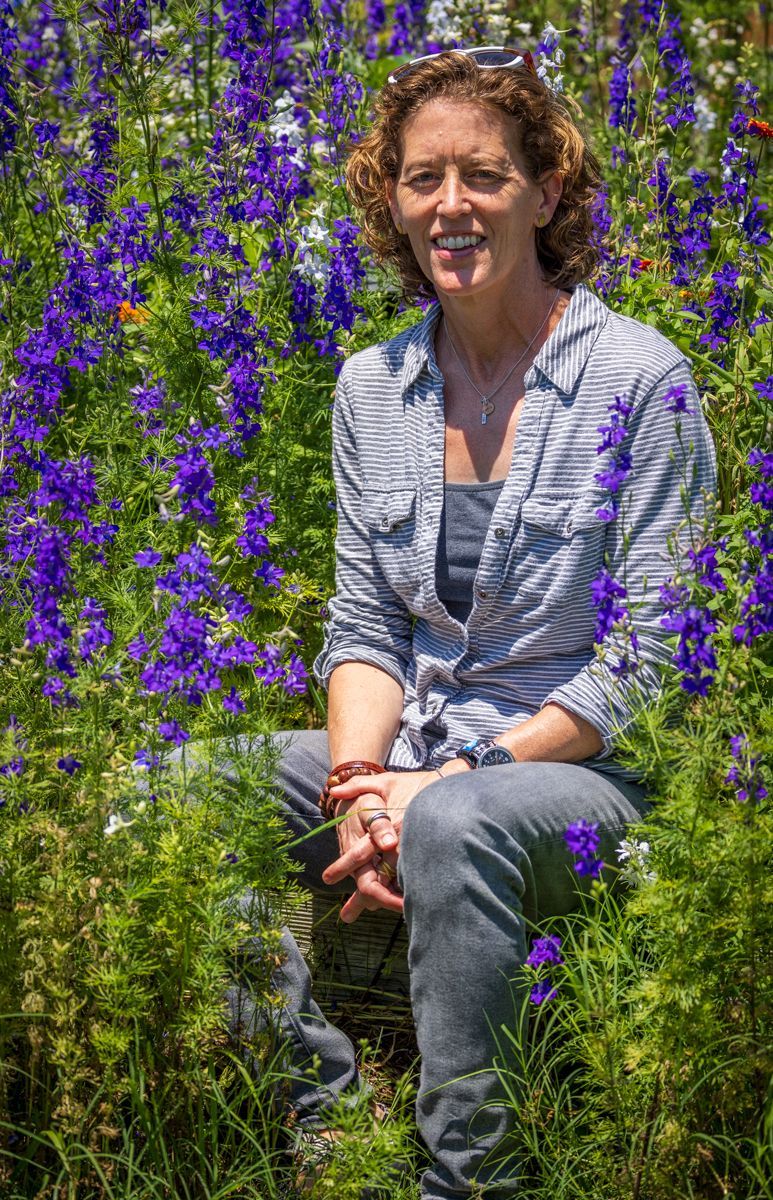 A woman is sitting in a field of purple flowers.