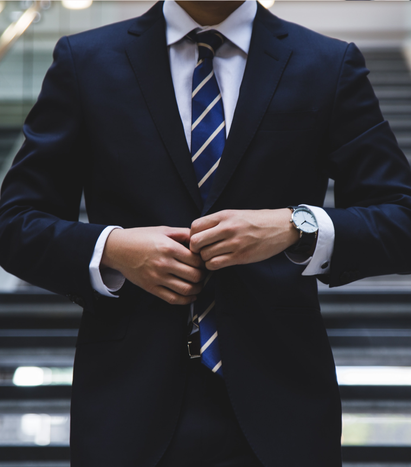 Um homem de terno e gravata com um relógio no pulso