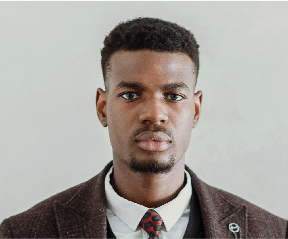 A man in a suit and tie is looking at the camera.