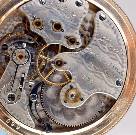 Close-up of a mechanical watch movement with visible gears, springs, and polished metal plates