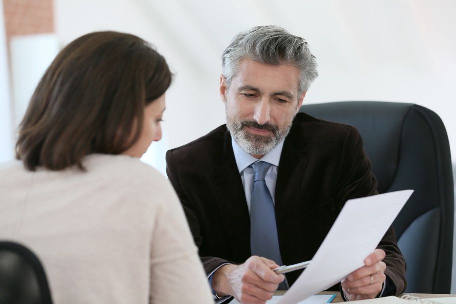 Experienced male attorney reviewing paperwork with a female client.