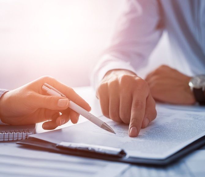Close-up of hands pointing to details on a legal contract during a meeting