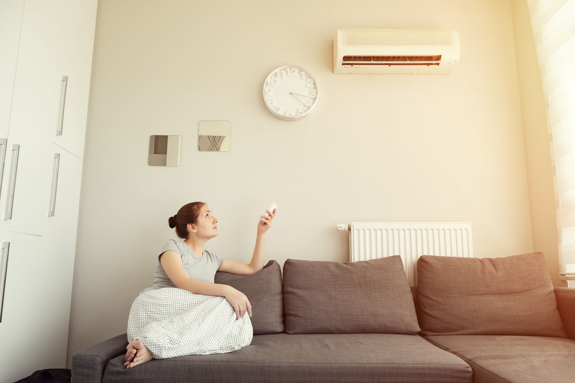 Homeowner using remote control to operate ductless mini-split system in Ridgeland, Mississippi.