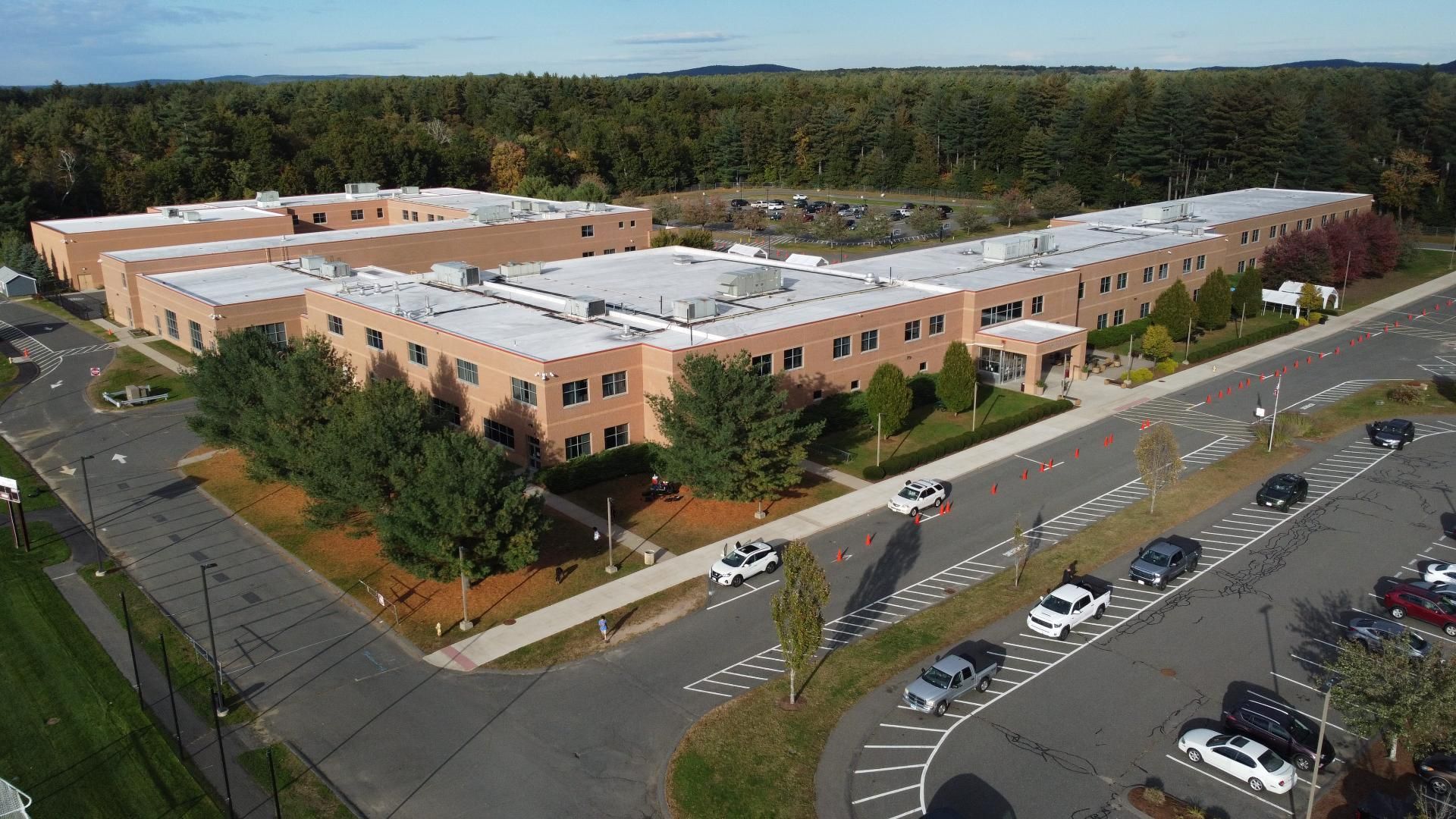 An aerial view of a large building with cars parked in front of it