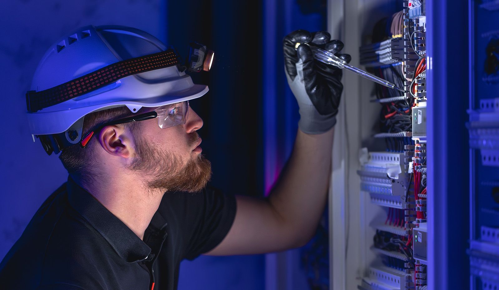 A licensed Advanced Mechanical Services electrician performs repairs to an electrical panel