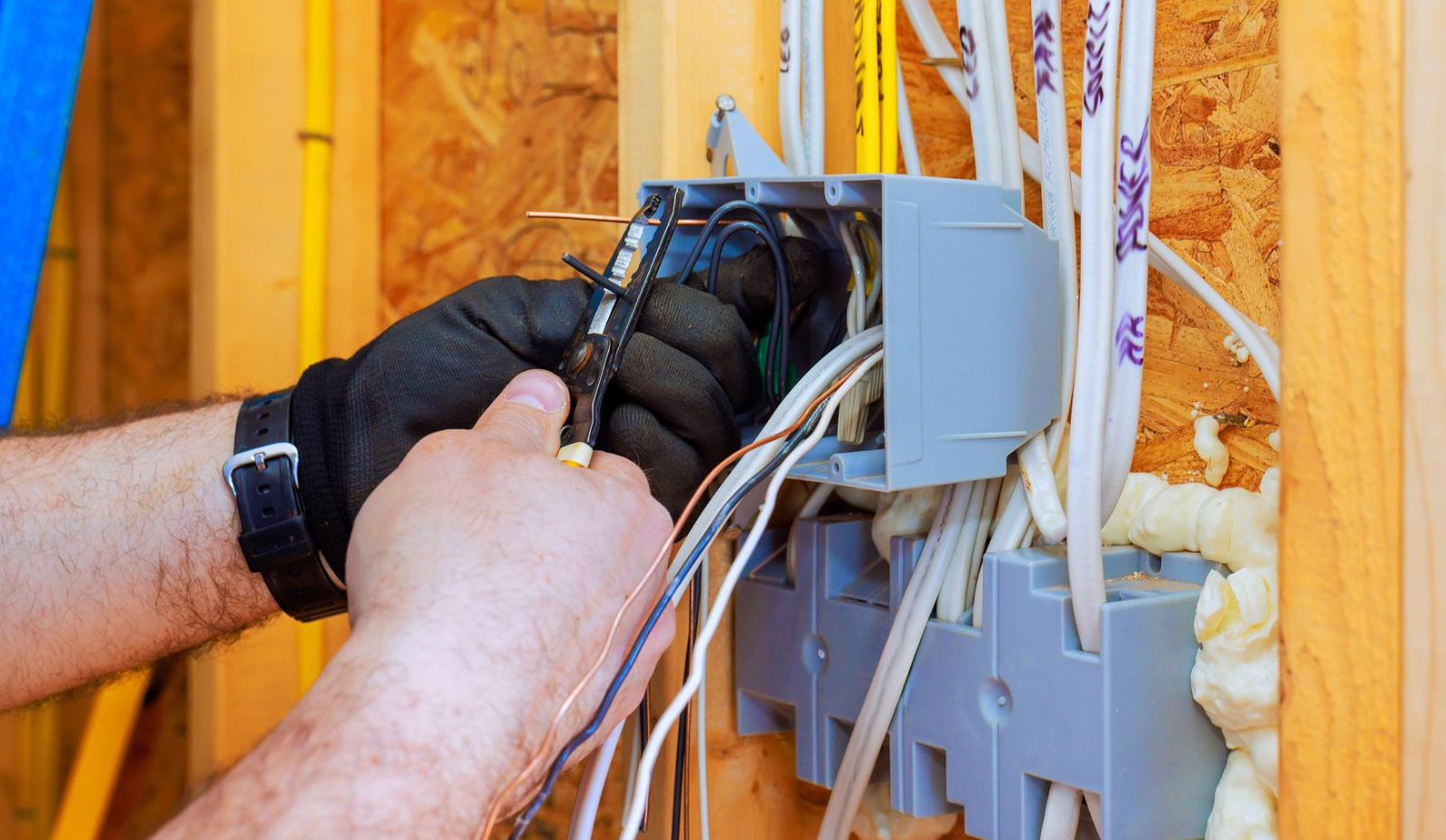An electrician wiring an electrical outlet for a new home construction in Massachusetts. 