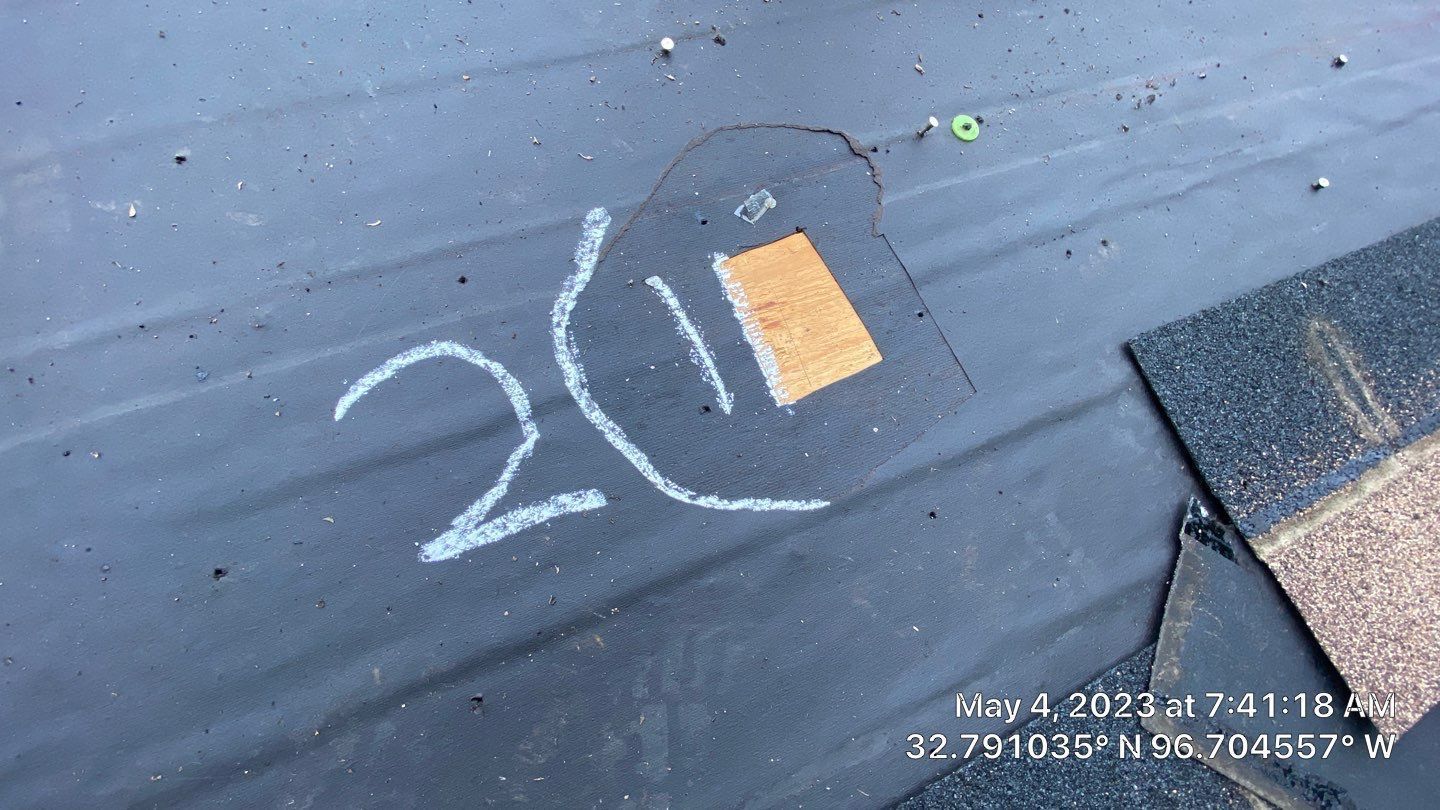 Black asphalt roof with a chalk-outlined area marked 