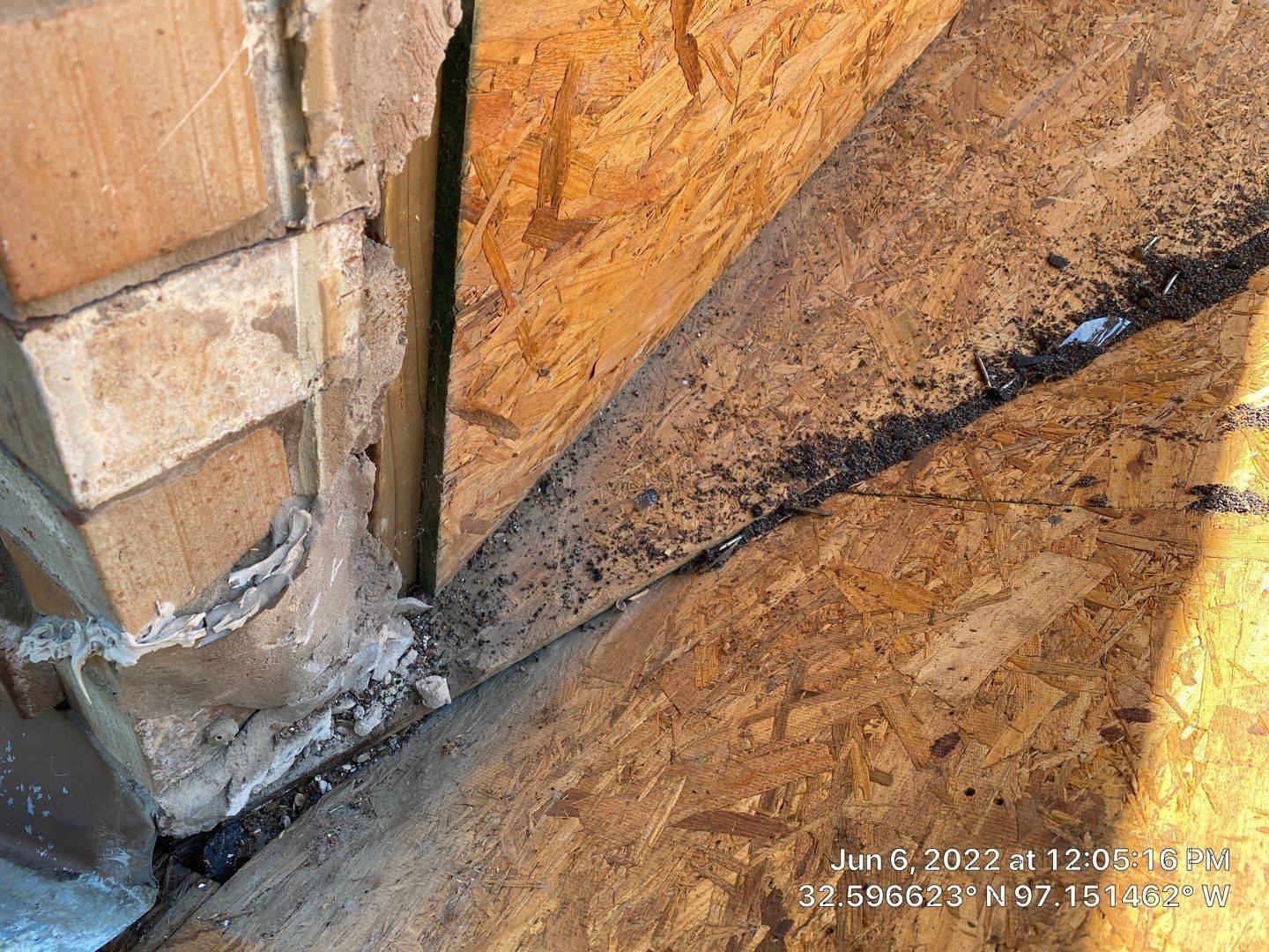 OSB wood and brick abutment with dark debris.