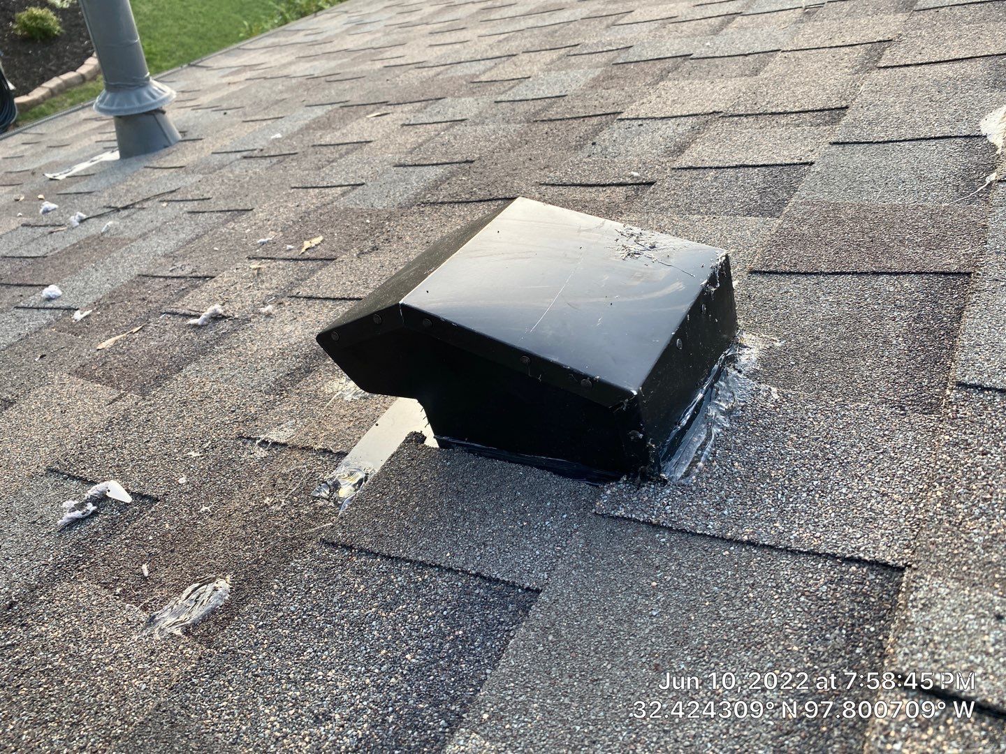 Black roof vent on a weathered asphalt shingle roof.