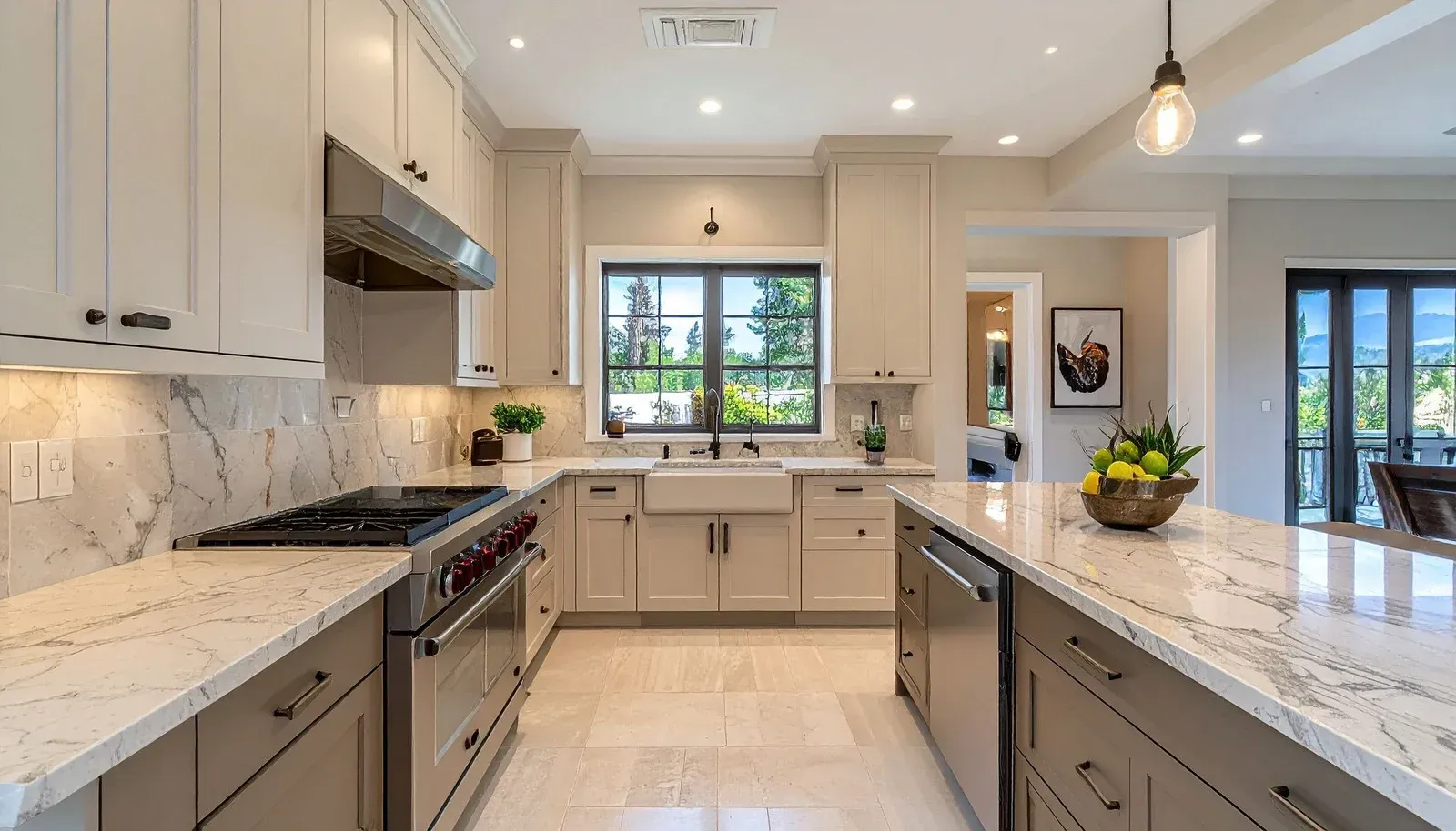 U-shaped kitchen with light gray cabinetry, marble countertops, stainless steel appliances, and a central island.
