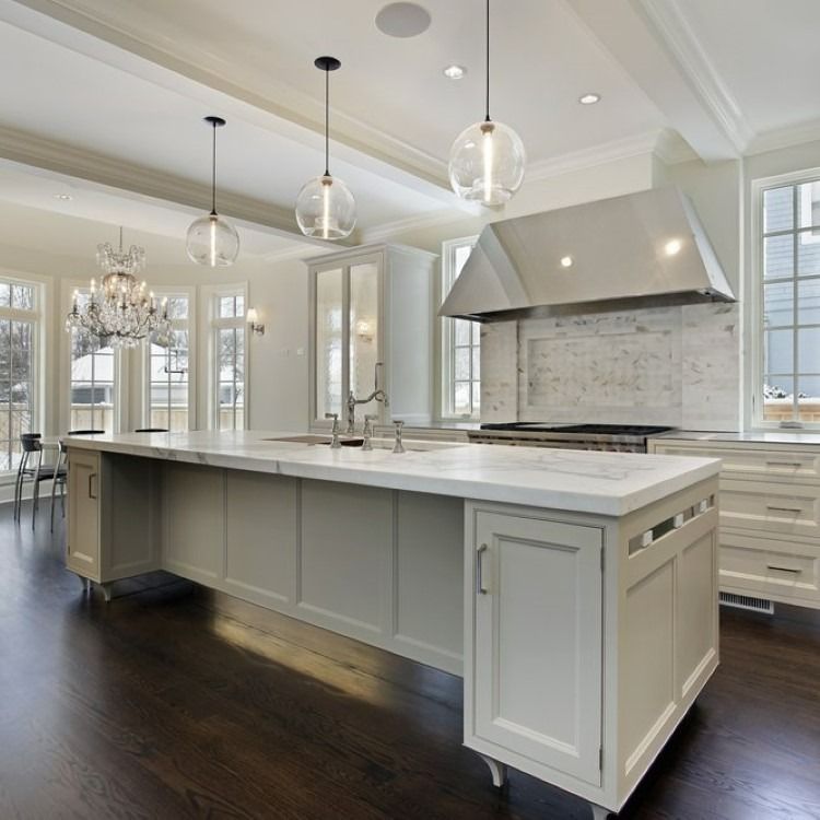 Elegant, modern kitchen with a large island, stainless steel appliances, and dark wood floors.