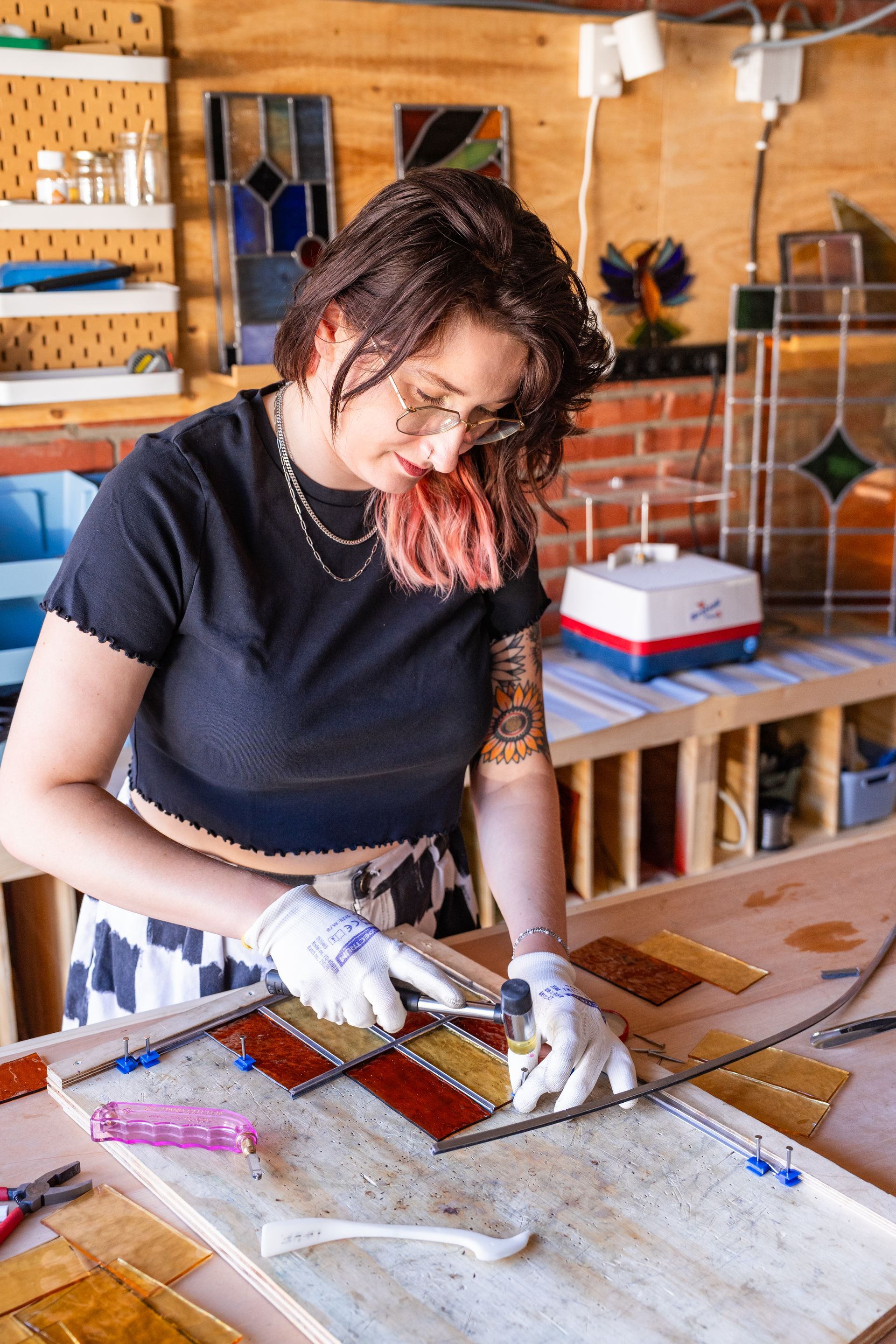 Lieke Kleverwal snijdt glas aan de werkbank in haar atelier