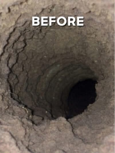 Close-up of a dark, round hole with textured, uneven walls. The word