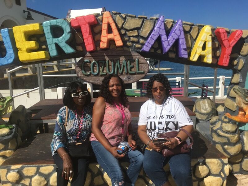 Three women smiling in front of the