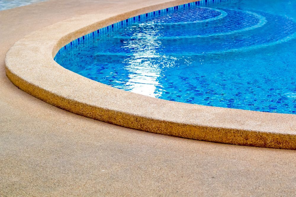 Pool's Edge, Tan Concrete Meets Blue-tiled Water With Spiral Design — Dean Thomas Pools in Manunda, QLD