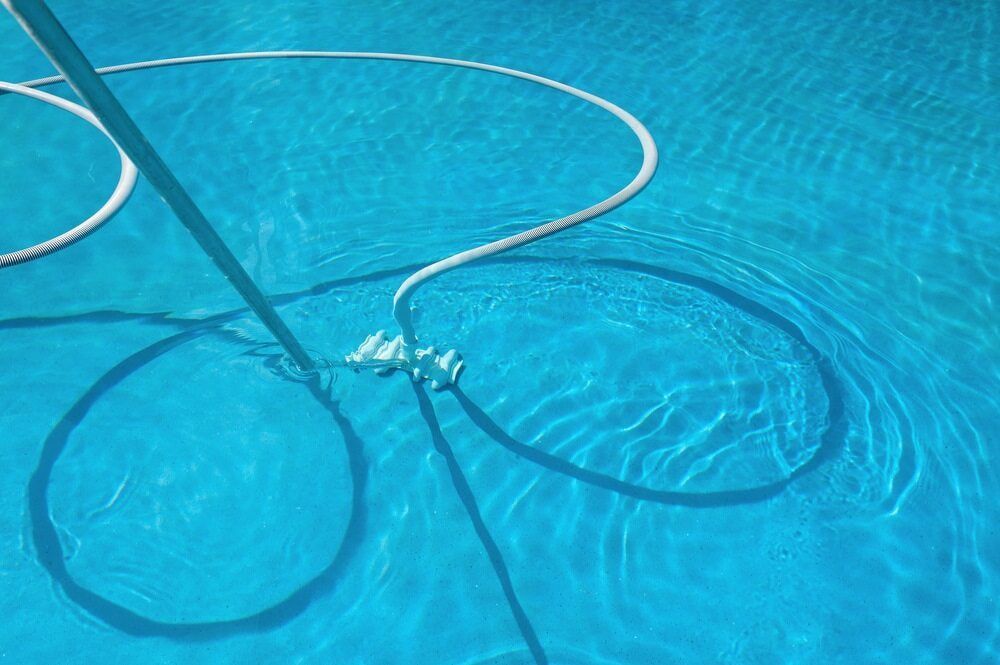 Pool Vacuum Cleaning a Clear Blue Pool, Creating Circular Patterns — Dean Thomas Pools in Manunda, QLD
