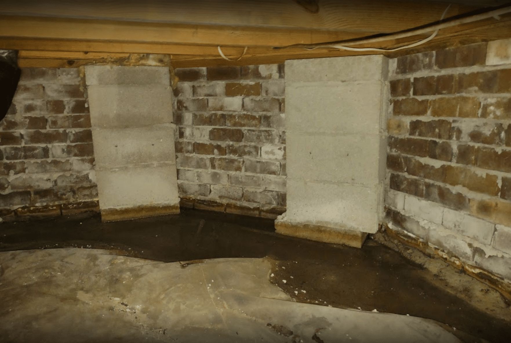 Insulated ductwork running through a construction area, silver and gray, supported by vertical posts.