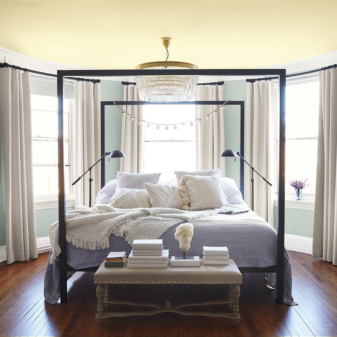 A bedroom with a canopy bed and a coffee table