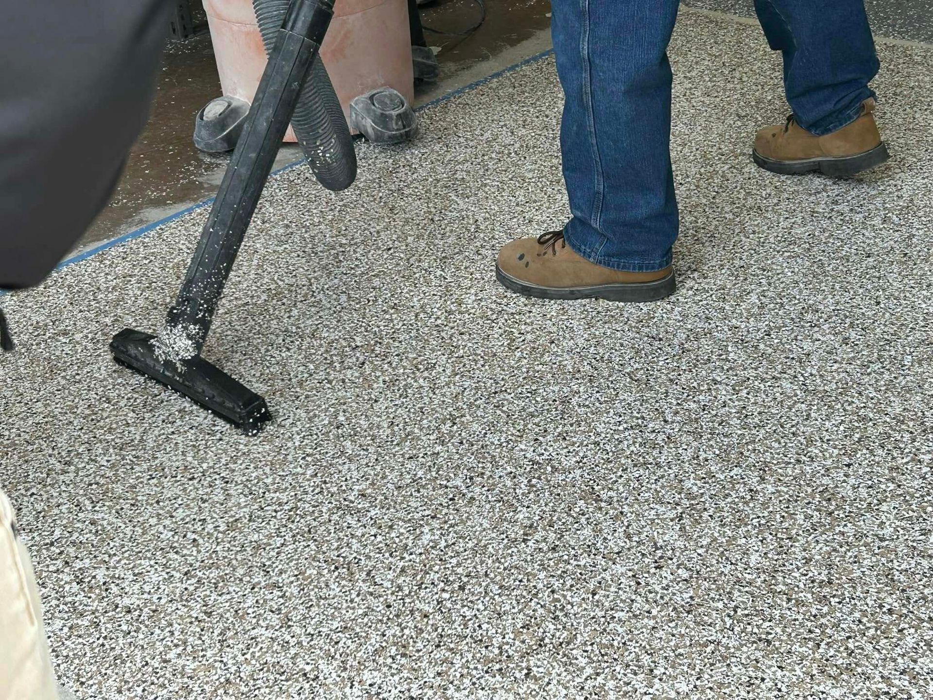 A person is using a vacuum cleaner to clean a carpet.
