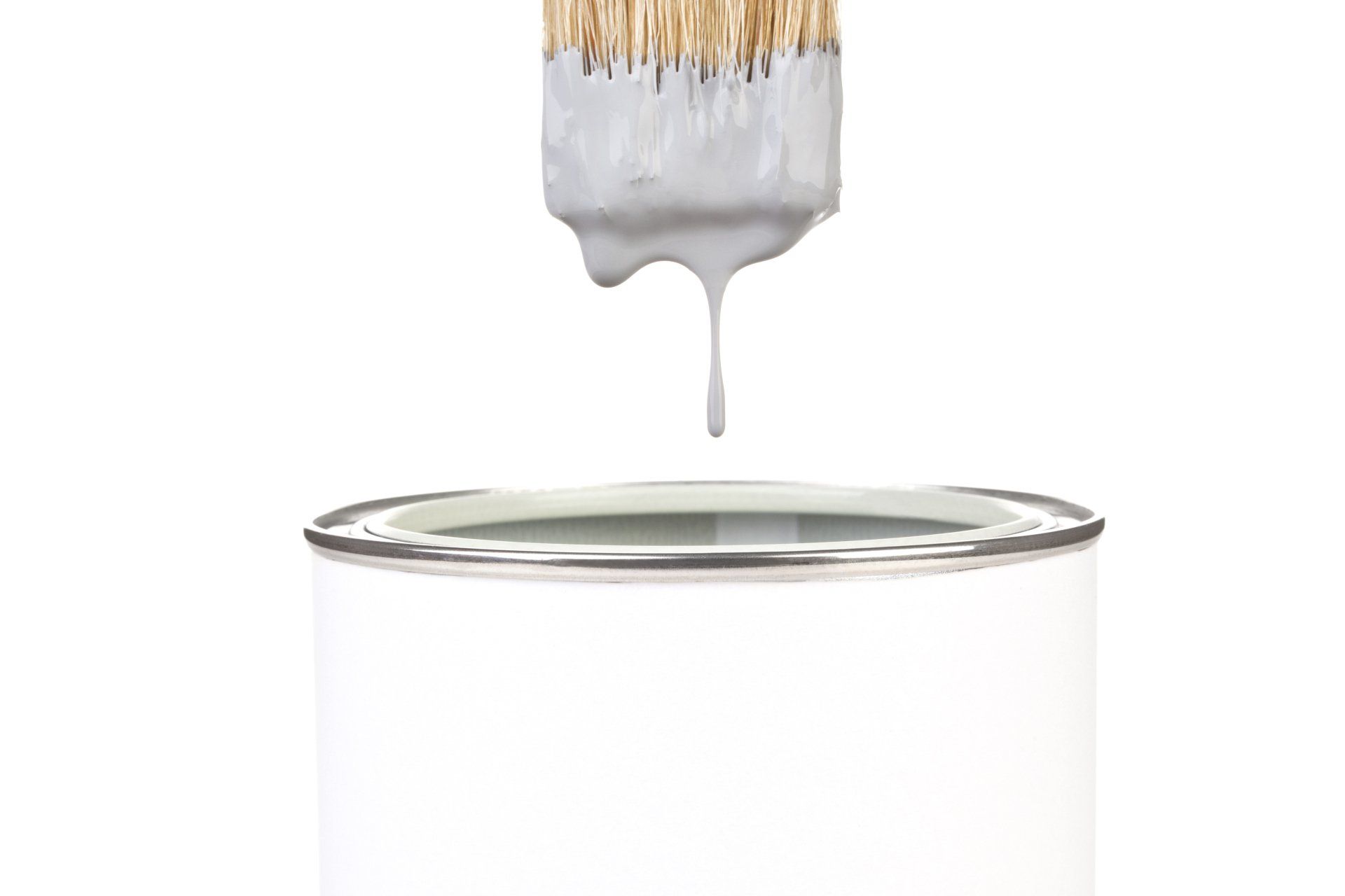 A paint brush is dripping paint into a can.
