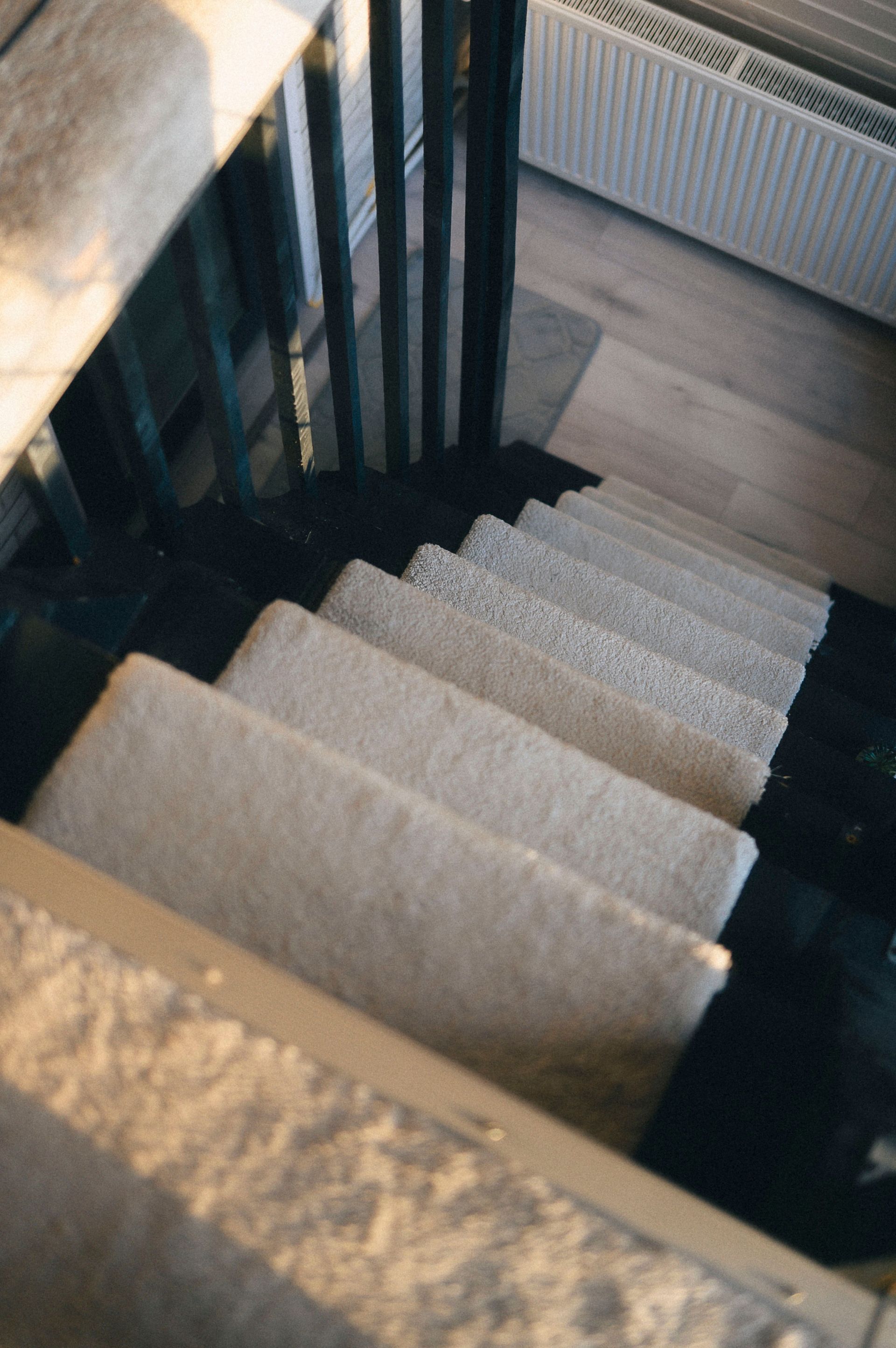 Red patterned carpet covering an indoor staircase with a wooden railing