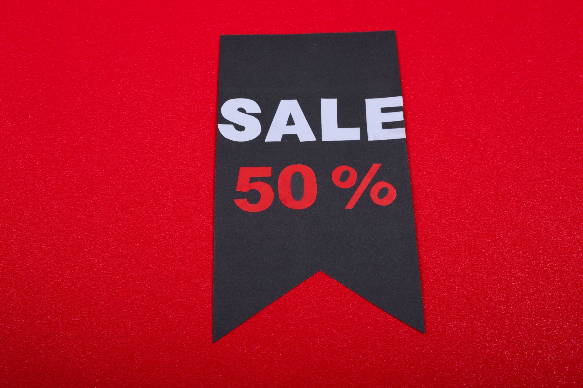 Black sale tag with “SALE 50%” in white and red on a red background