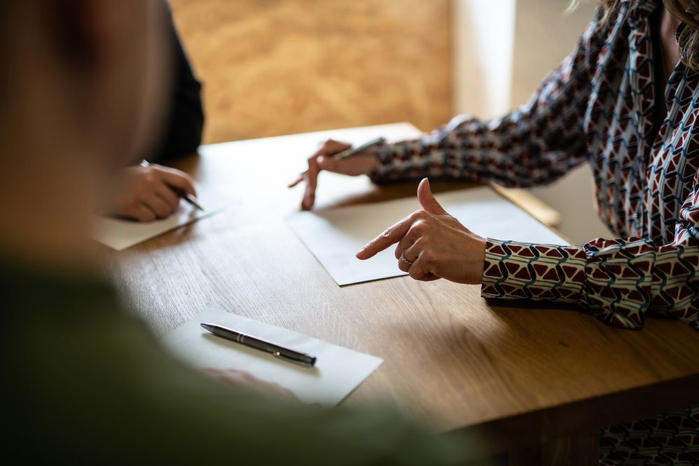 Woman sitting at a table pointing at a piece of paper — Mediator & Counsellor in Kingscliff, NSW
