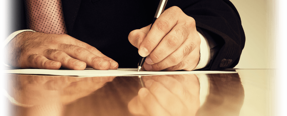 man writing on paper with a pen