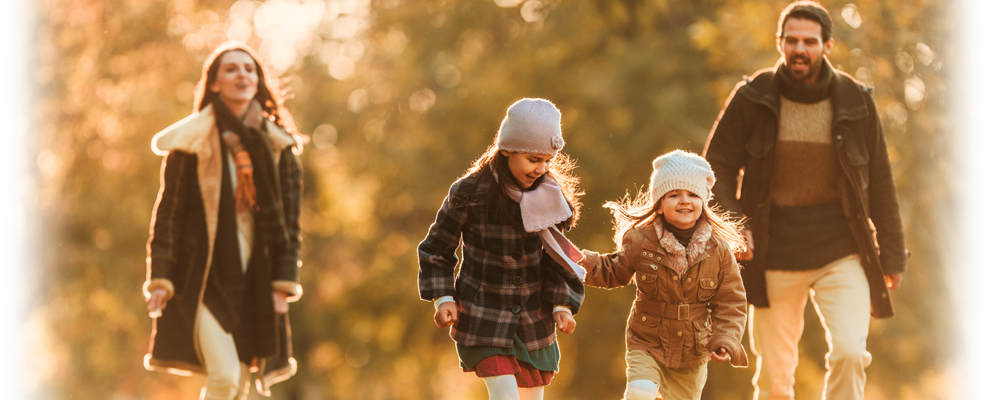 family dressed in  winter clothing walks outdoors