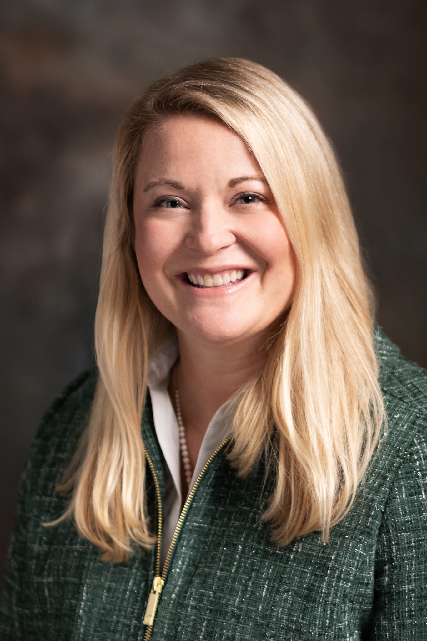 Meghan McEvoy headshot - a blonde woman smiling in a dark green sweater