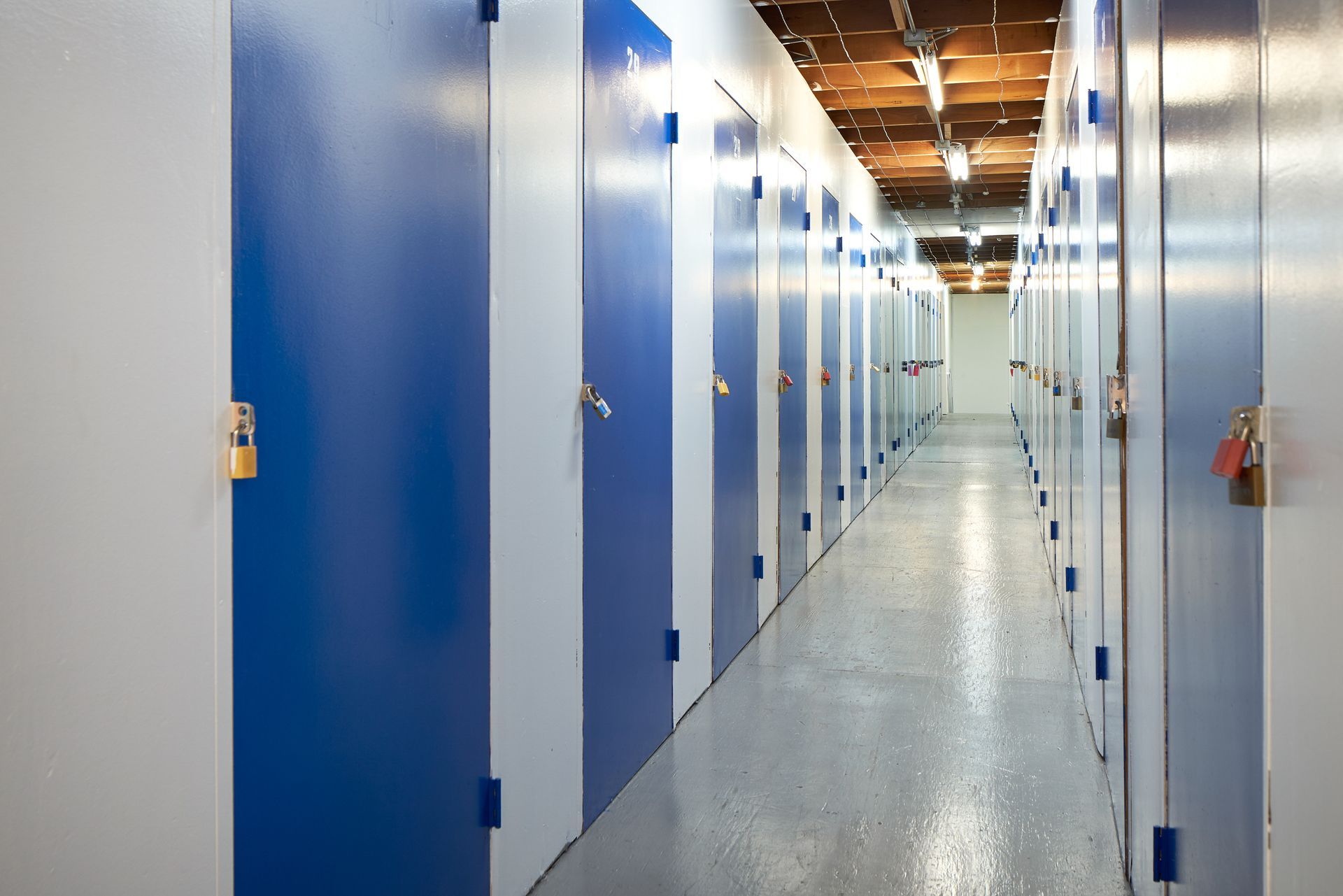A long hallway with blue doors and white walls