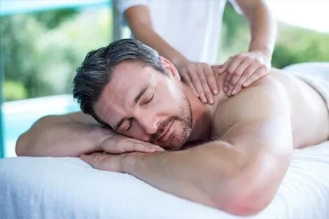 A man is laying on a massage table getting a massage.
