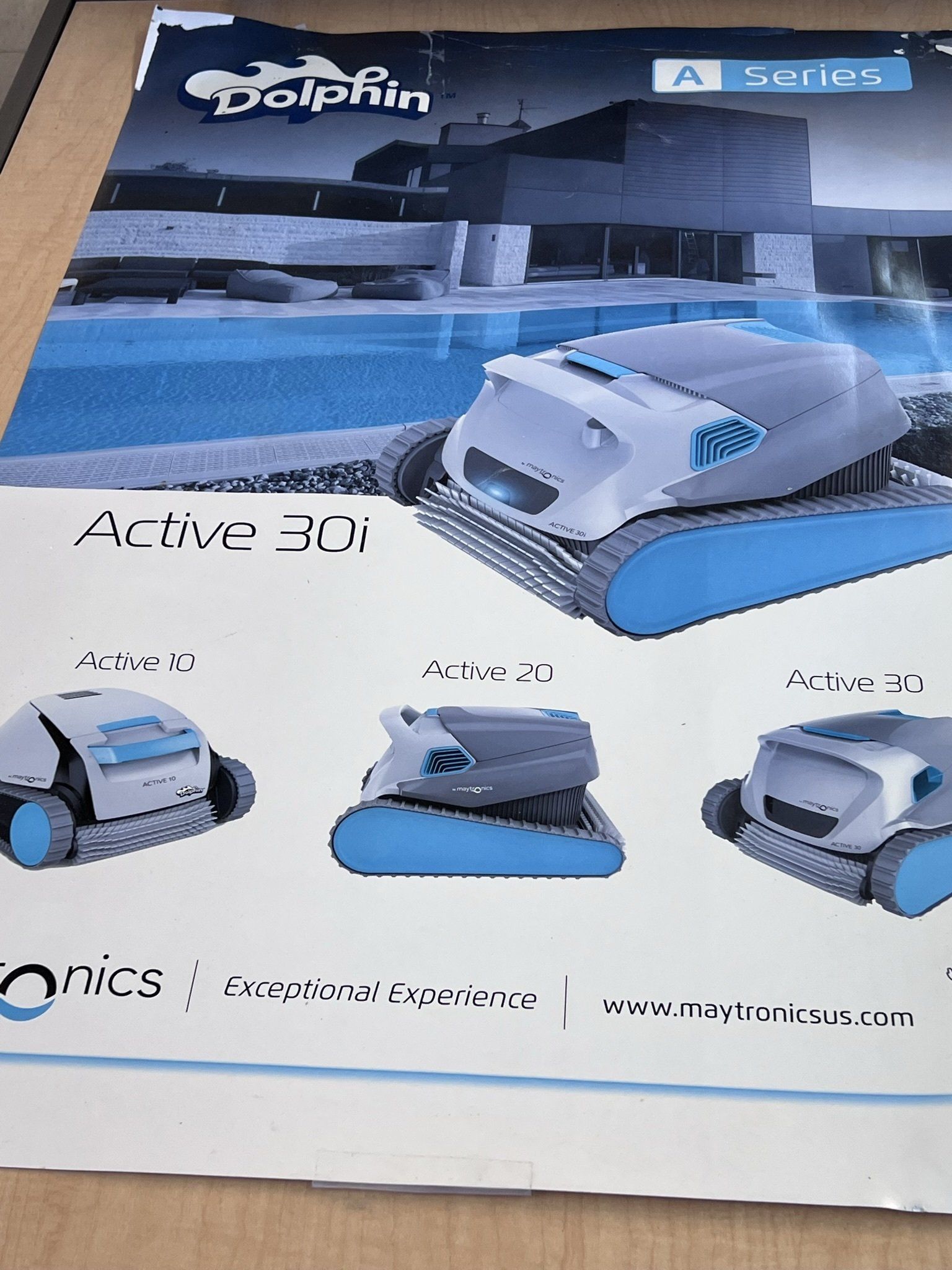 Dolphin Active 30i pool cleaner ad: robotic pool cleaners, blue and white, with various models displayed.