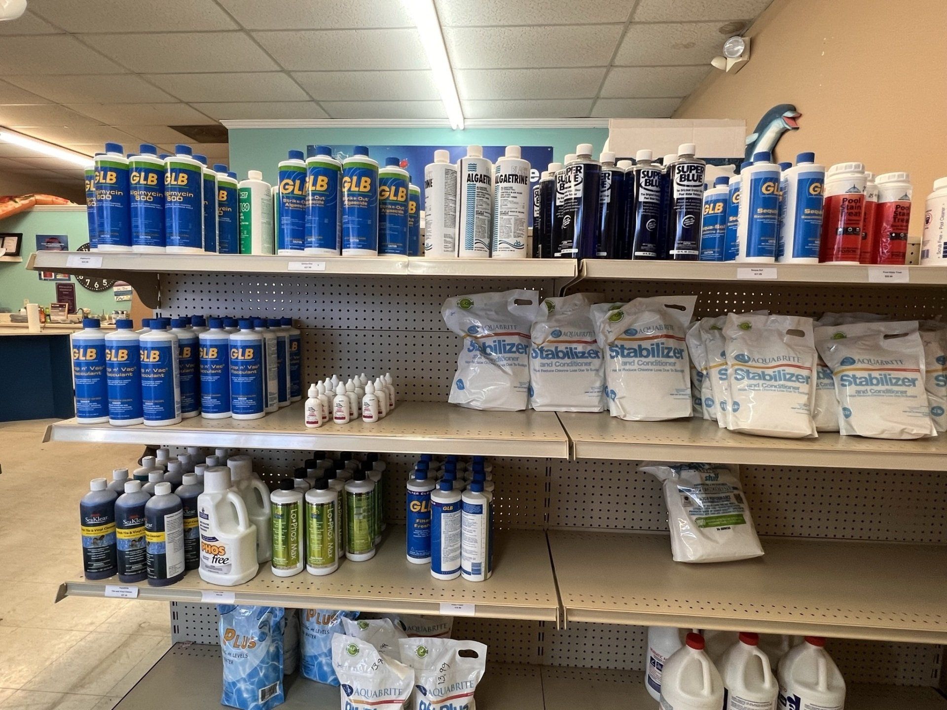 Shelves stocked with blue and white pool chemicals in a store.