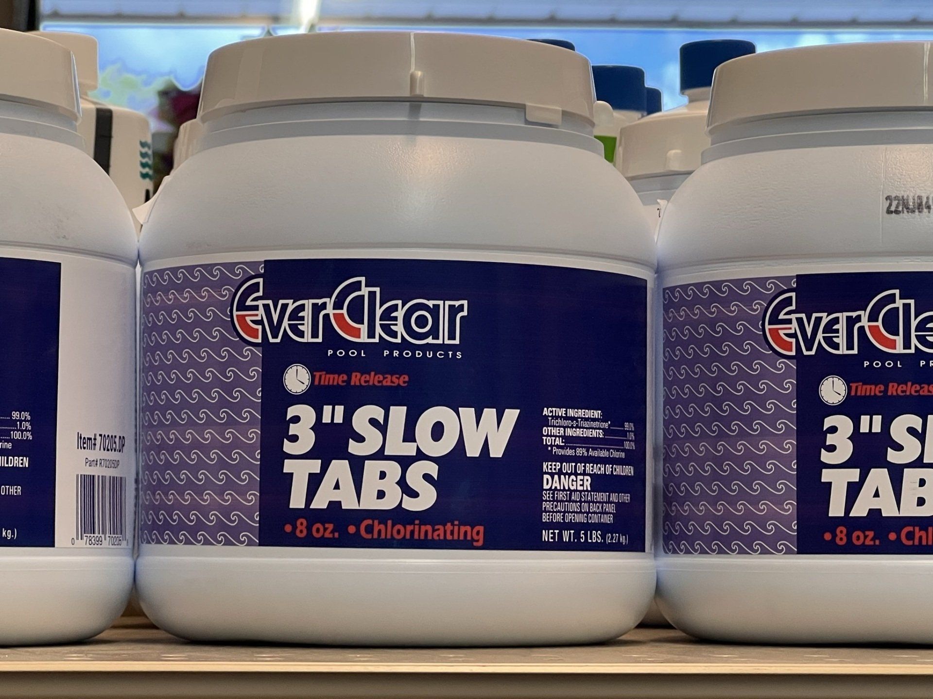 Three white EverClear pool chemical containers labeled 