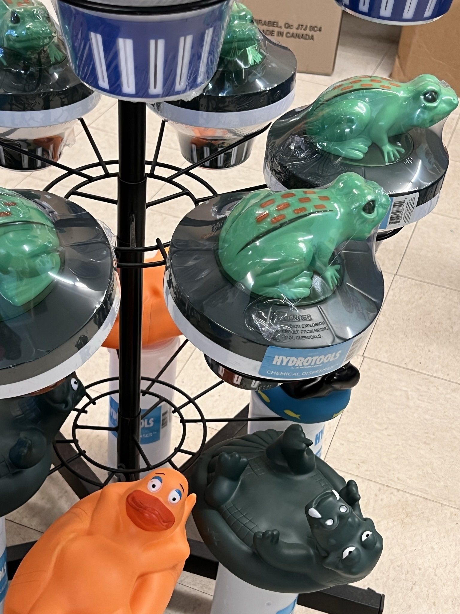 A display stand with plastic frog and alligator shaped water toys.