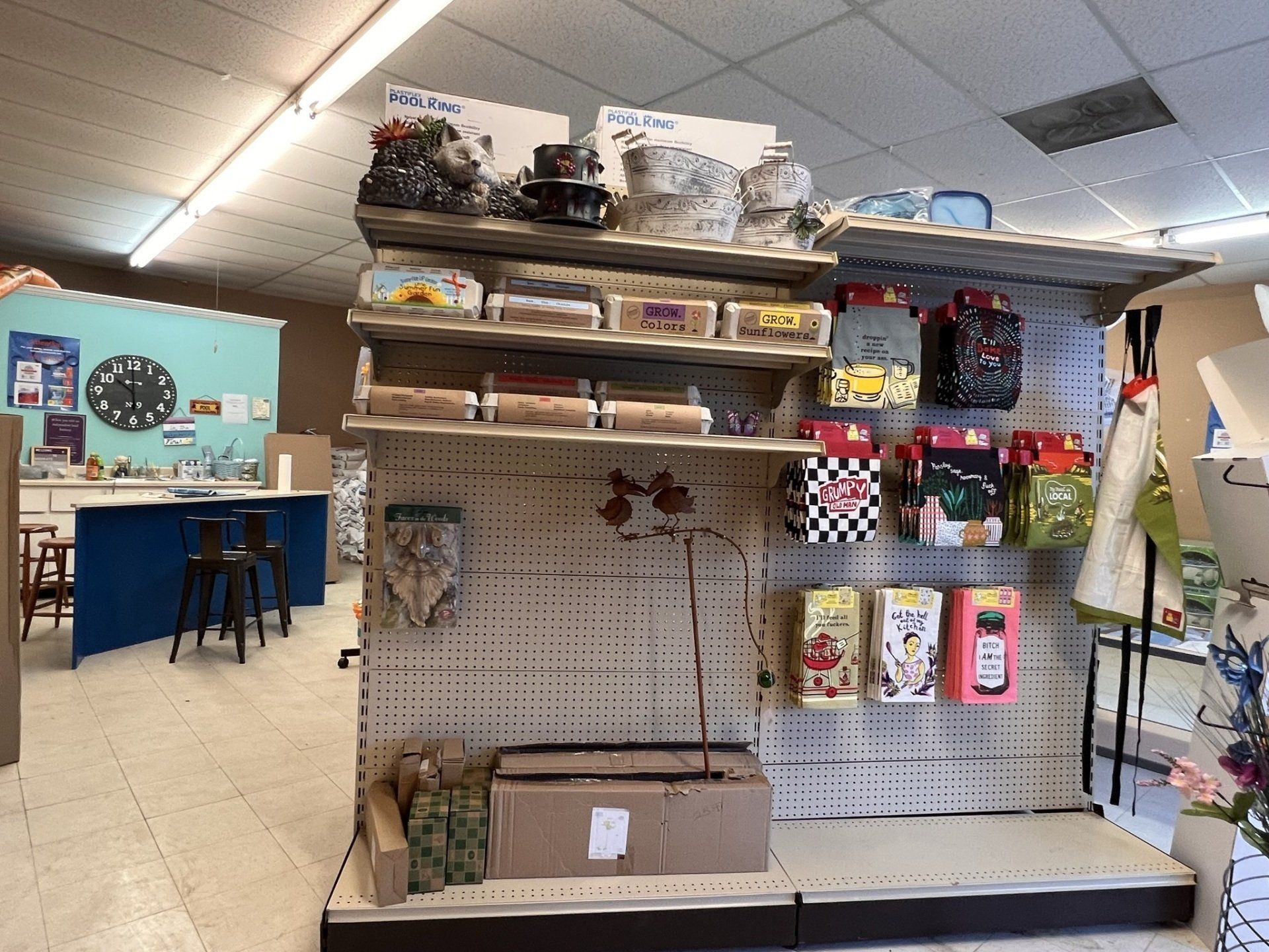 Shelves of craft supplies in a store; boxes, bags, and tools.