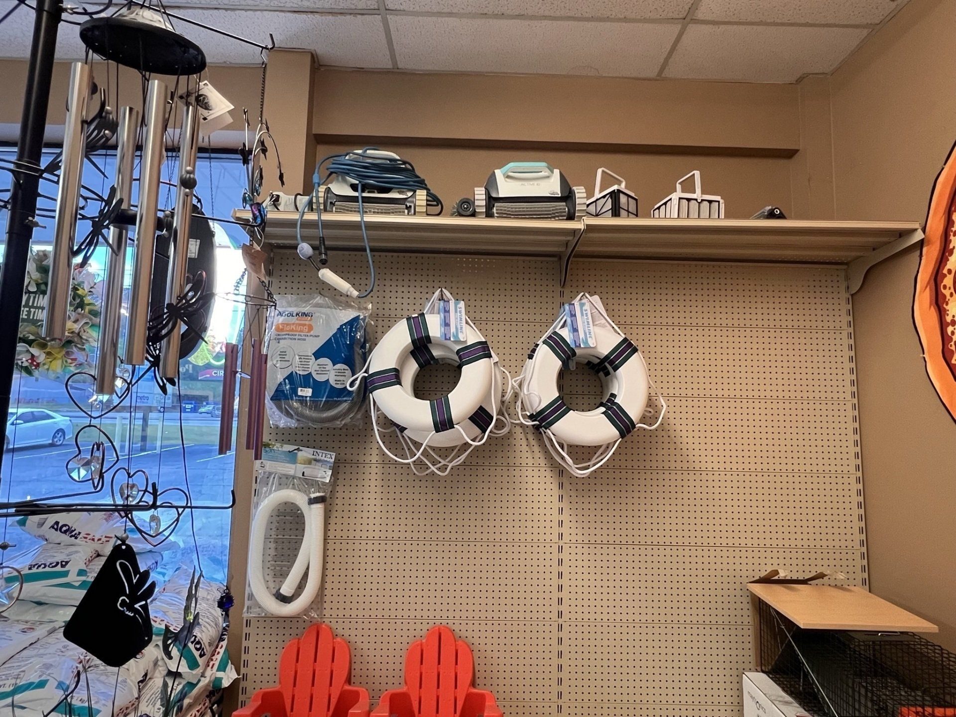 Display of nautical-themed items in a store: life preservers, wind chimes, and Adirondack chairs.