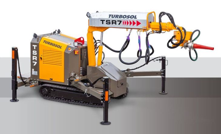 Spruzzatrice per calcestruzzo cingolata Turbosol TSR7 con braccio portatubo arancione e stabilizzatori, vista laterale