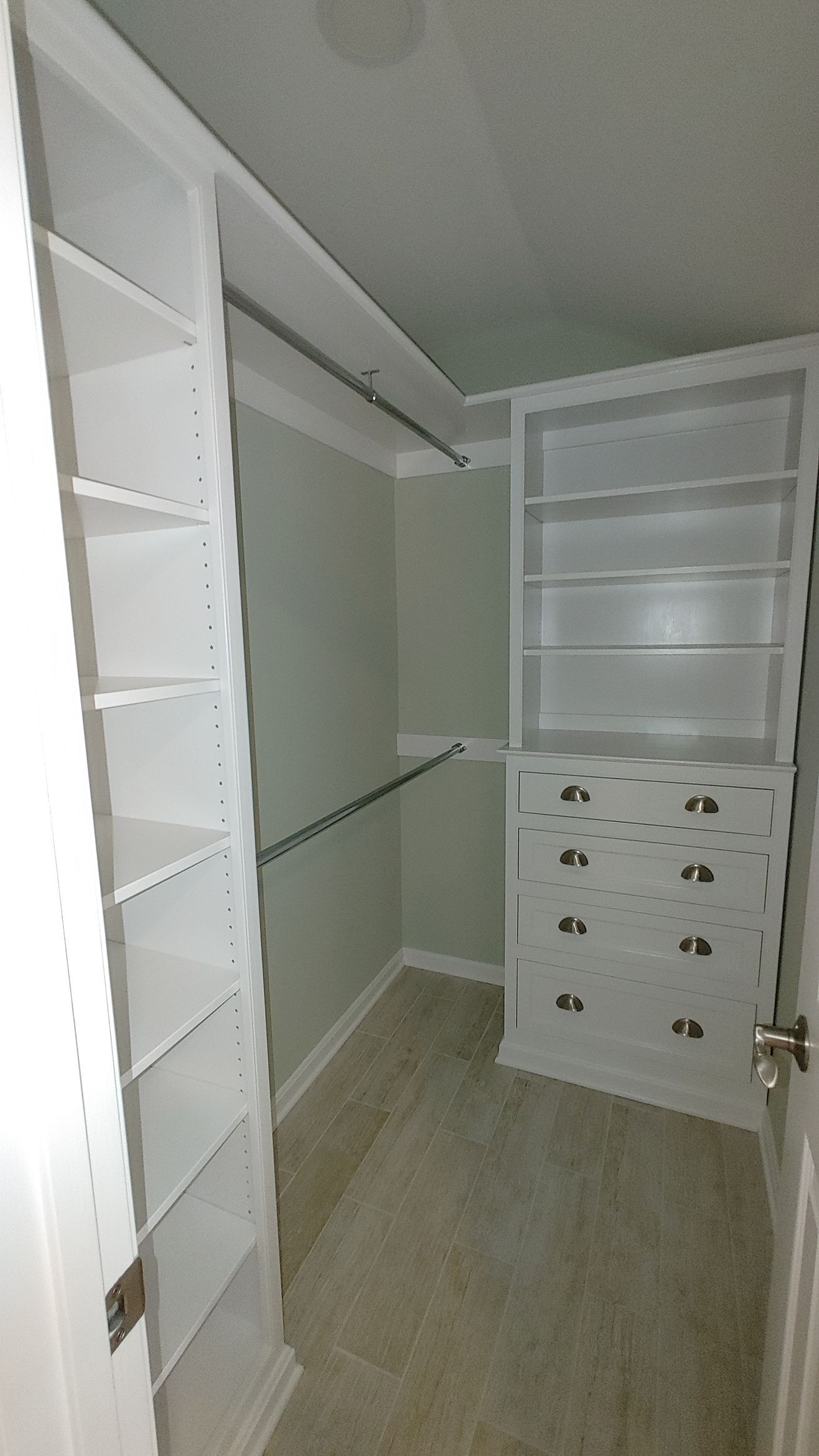 A modern kitchen featuring wood cabinets, white upper cupboards, a large island with three stools, and wooden floors. A modern kitchen featuring wood cabinets, white upper cupboards, a large island with three stools, and wooden floors.