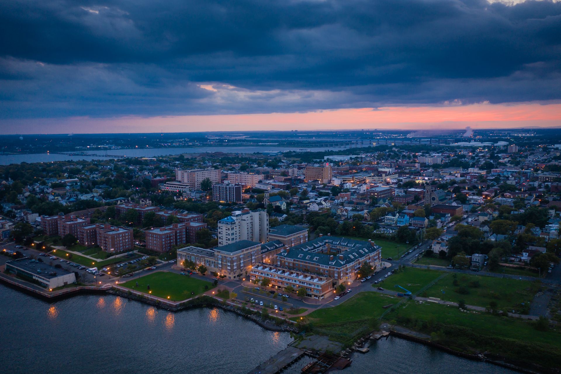 An aerial view of a city and a body of water at sunset.