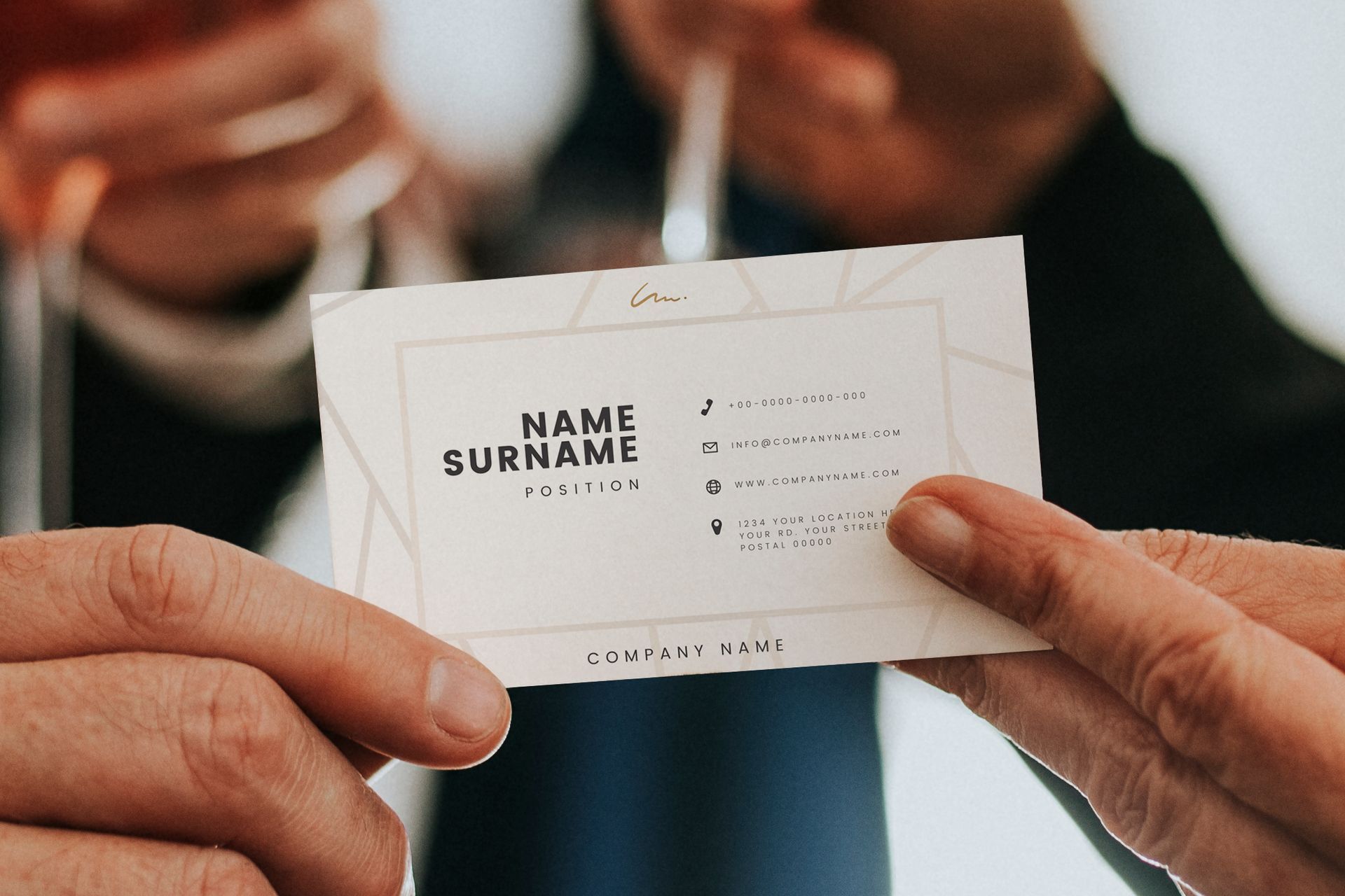 Close-up of two hands holding a business card showing name, position, and contact information
