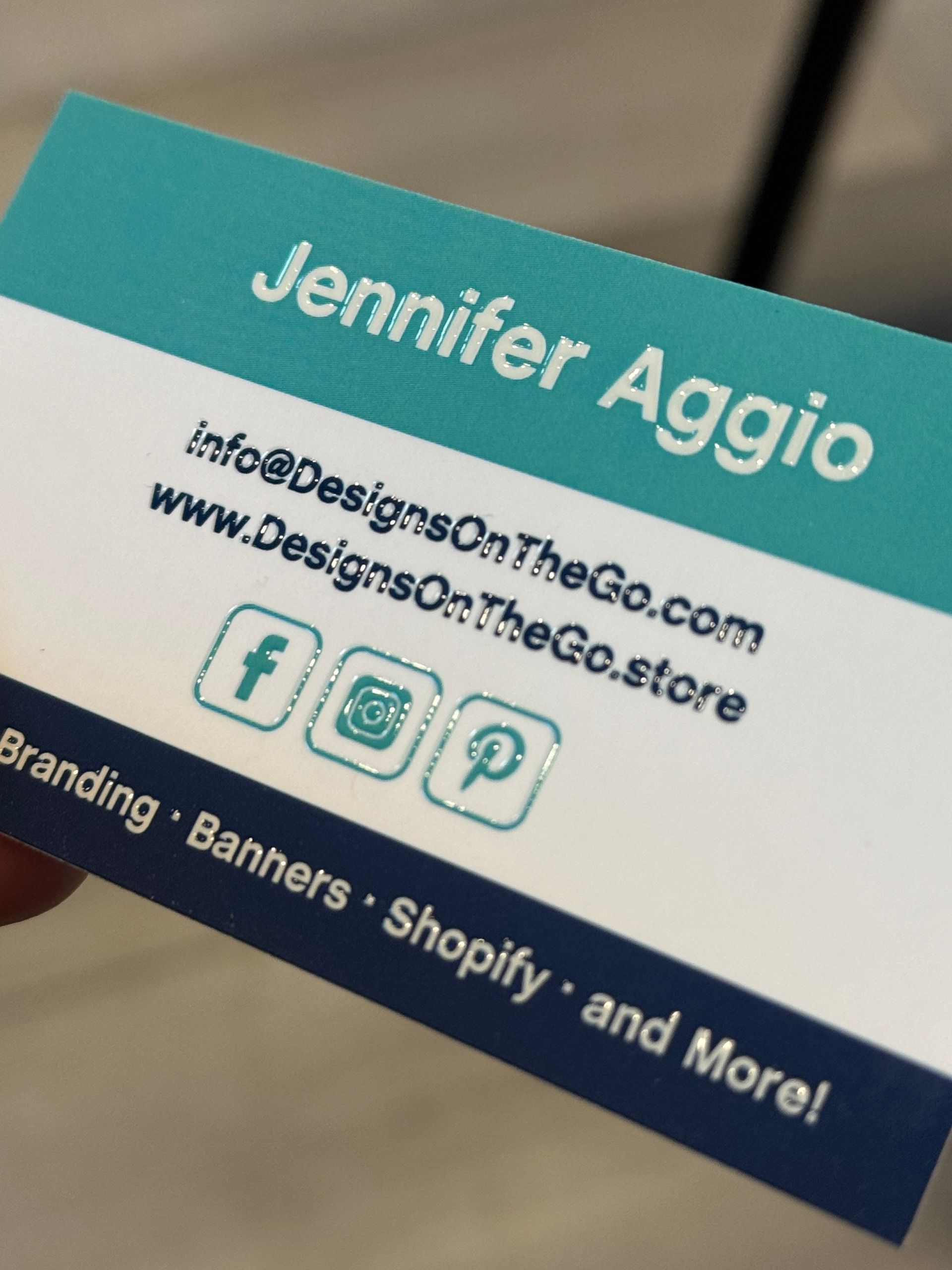 Designs On The Go business card showing name, email, website, and social media icons